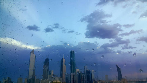Panoramic view of buildings against cloudy sky