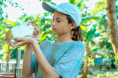 Friendship, girl and mammal, beautiful white girl holding guinea pig, cute relationship