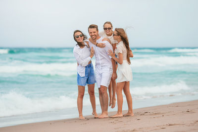 Smiling friends standing at beach