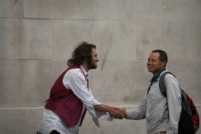 Young woman standing against wall
