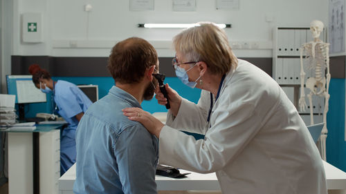 Doctor examining ear of patient