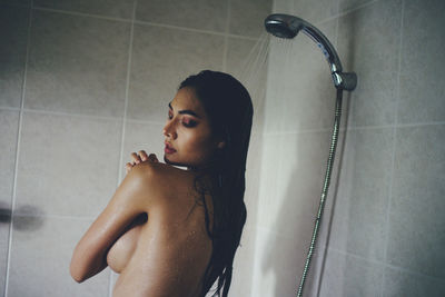 Seductive woman taking shower in bathtub