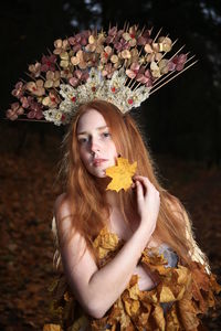 Portrait of beautiful young woman holding red flower