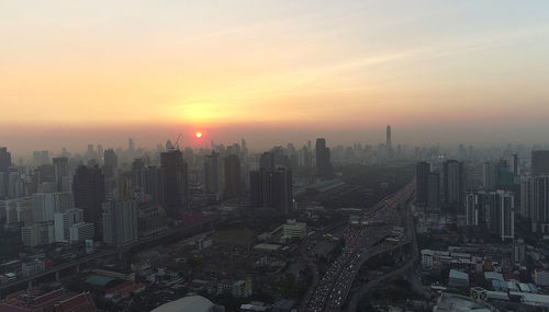 Aerial view of buildings in city during sunset