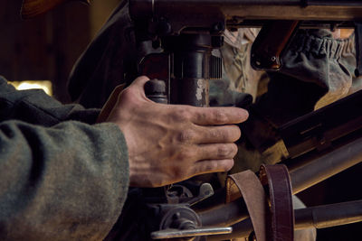 Cropped hand of man working on machine