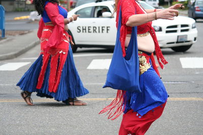 Rear view of women standing on road