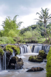 Scenic view of waterfall against sky