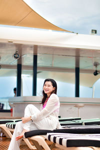 Portrait of smiling young woman sitting at airport