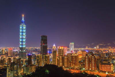 Illuminated buildings against sky at night