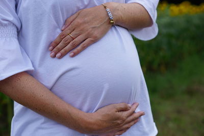 Midsection of woman with arms hair standing outdoors