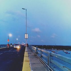 Vehicles on road against sky at dusk