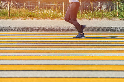 Woman running crosswalk, copy space. athletic woman jogging on city road. street workout