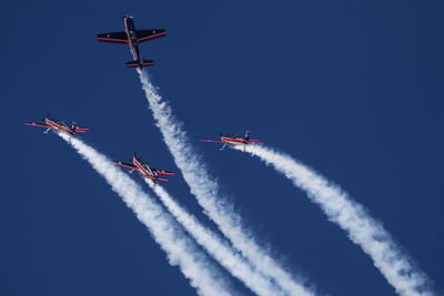 Low angle view of airshow against blue sky