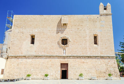 Low angle view of old building against clear blue sky