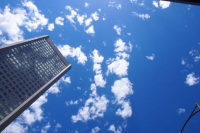 Low angle view of skyscraper against cloudy sky