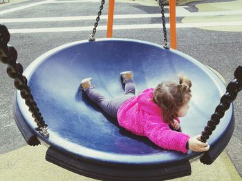 Girl playing on swing at playground