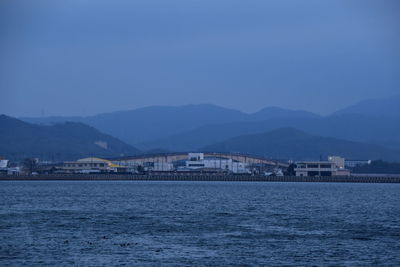 Scenic view of sea and buildings against clear blue sky