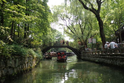 Bridge over canal against trees