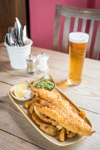 High angle view of meal served in plate with beer on table