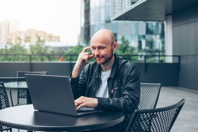 Man using mobile phone while sitting on table