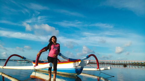 Full length of woman standing on sea against sky