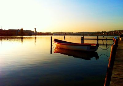 Boats in sea at sunset