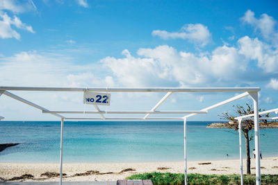 Information sign on beach against sky