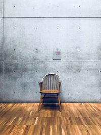 Empty chair on table against wall