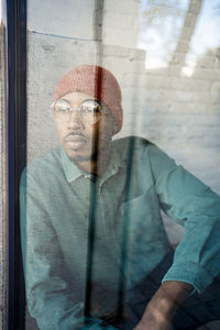 Mid adult man contemplating while looking through window