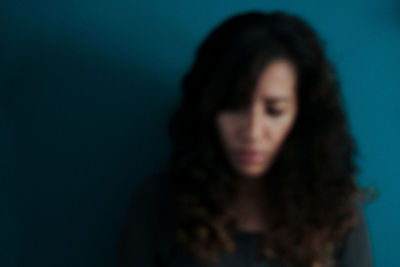 Close-up portrait of a young woman over black background