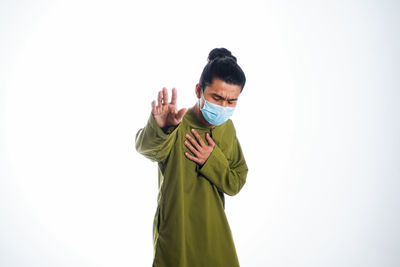 Portrait of young man standing against white background
