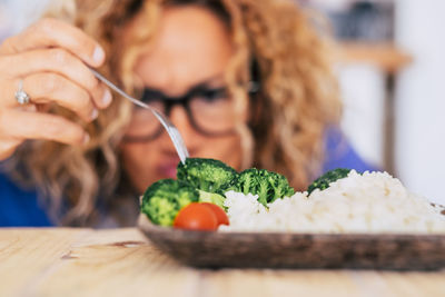Midsection of woman with ice cream on table