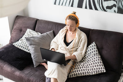Mid adult business woman working on laptop at home