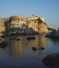 Castle by sea against clear sky