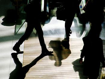 Low section of silhouette people walking on street