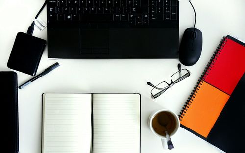 Directly above shot of office supply by laptop at desk