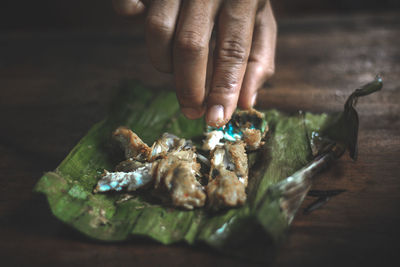 Close-up of person holding food on table