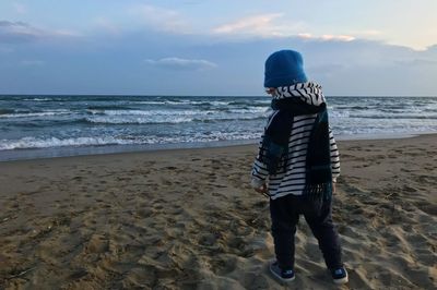 Full length of man standing on beach against sky