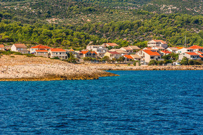 Houses by sea against buildings