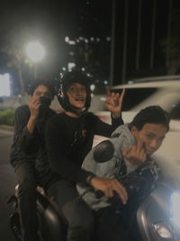 Young man holding camera at night