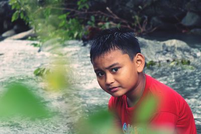 Portrait of boy sitting in stream