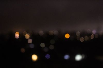 Defocused lights against sky at night