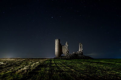 Caudilla castle on field against sky at night