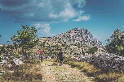 Rear view of people on mountain against sky