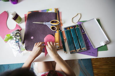 High angle view of girl making greeting card on table