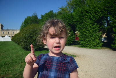 Cute girl gesturing while standing at park