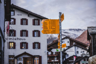 Road sign against buildings in city