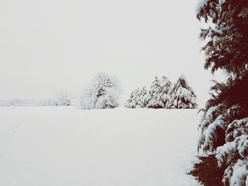 Snow covered field against clear sky