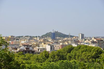 Buildings in city against clear sky