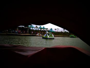 People in boat sailing on river